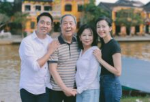 A family poses for a photo outdoors by a river.