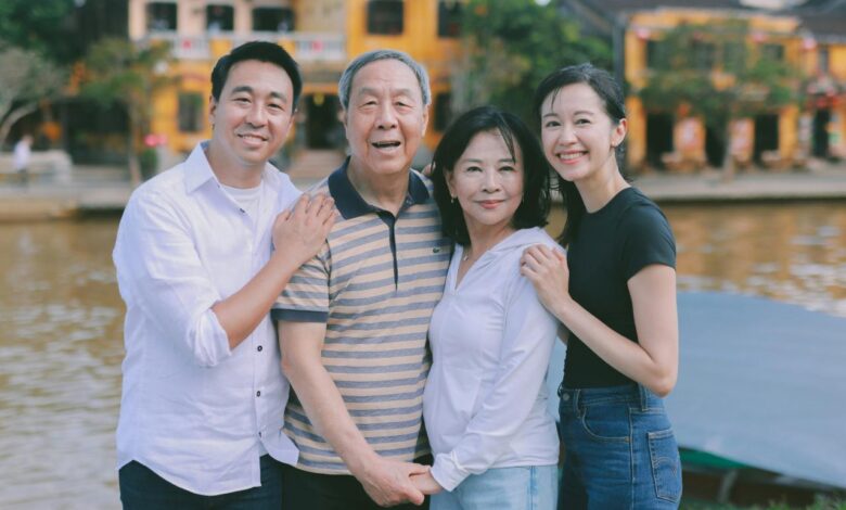A family poses for a photo outdoors by a river.