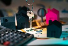 A calculator, keychain, and house model on a table