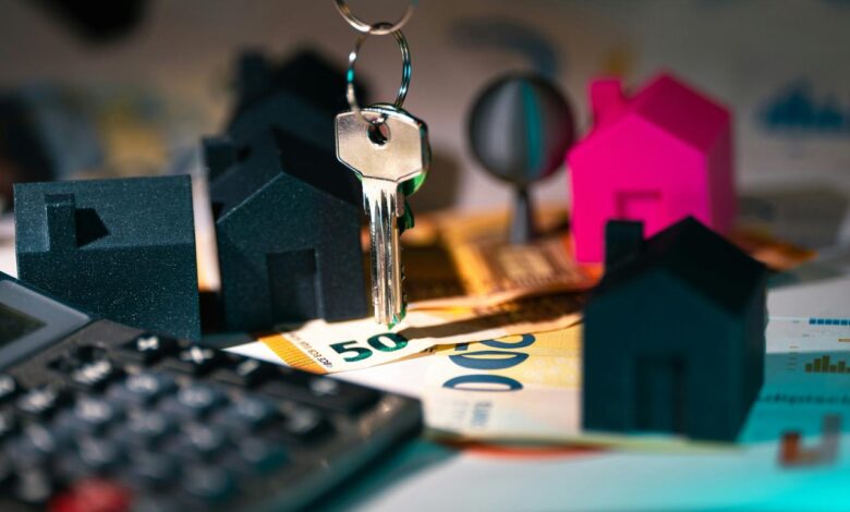 A calculator, keychain, and house model on a table