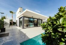 white and grey concrete building near swimming pool under clear sky during daytime